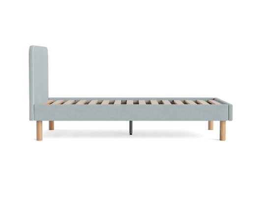 Light grey upholstered bed frame with wooden slats and round wooden legs, viewed from the side.