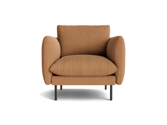 Modern tan armchair with rounded armrests and cushioned seat, supported by slim black legs.