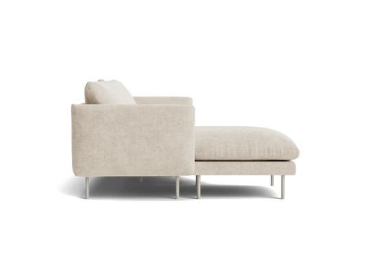 Side view of a beige fabric chaise lounge with a cushion, featuring slender metal legs.