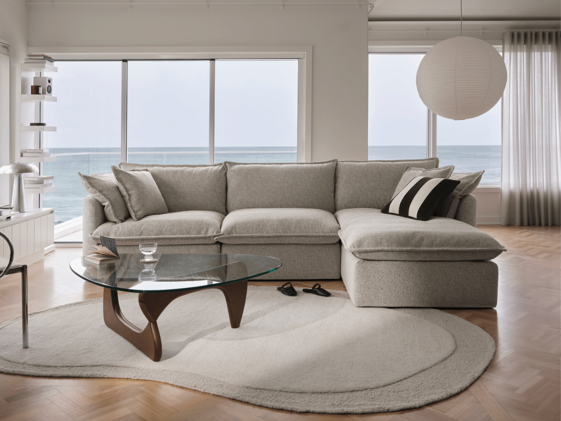 Light grey boucle Koala Tamworth sofa with chaise, Noguchi glass coffee table and paper lantern pendant