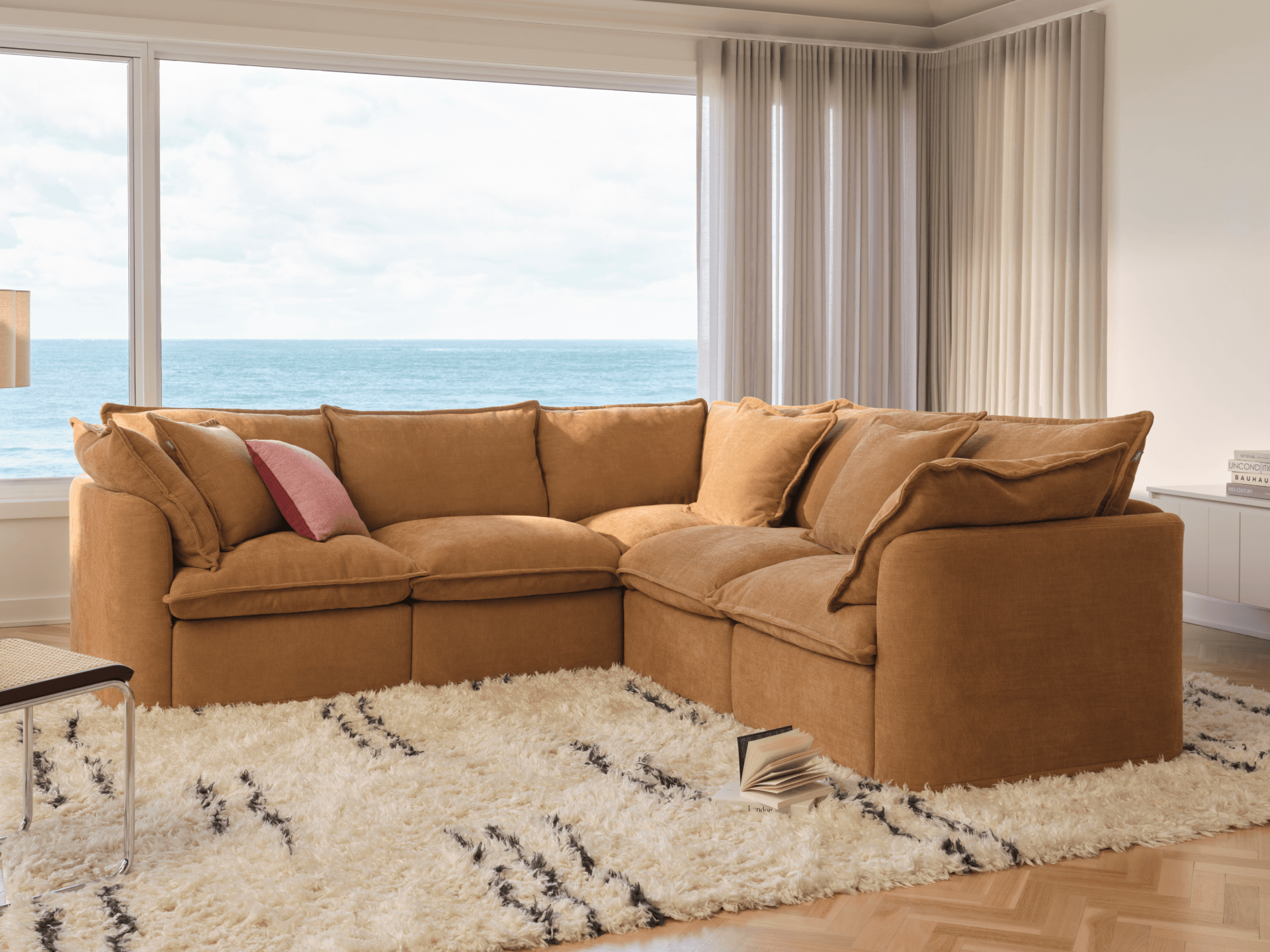 Camel Koala Tamworth modular sofa in corner configuration with pink cushion and Berber shaggy rug