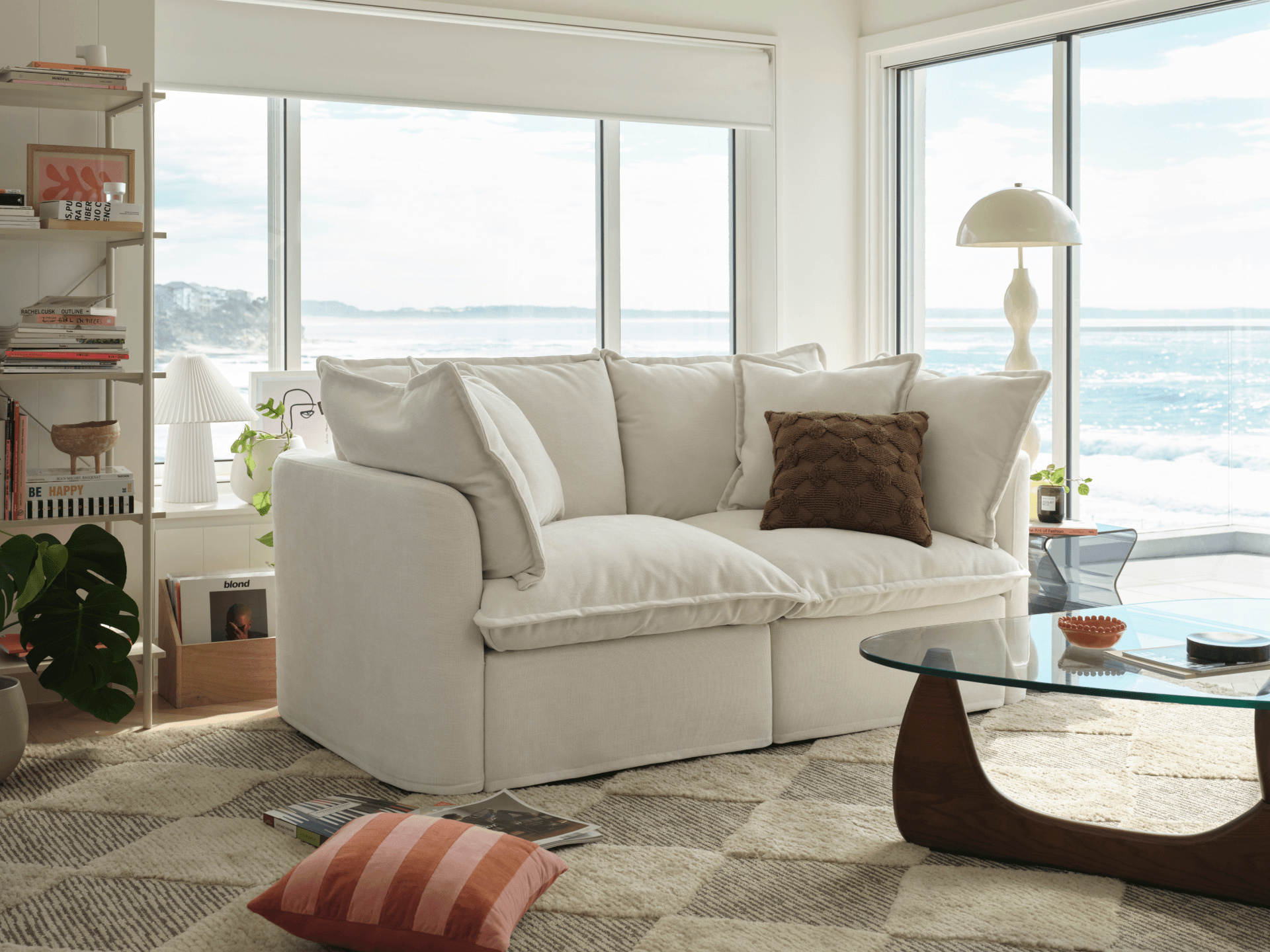 White Koala Tamworth sofa in bright coastal living room with ocean views, glass coffee table and bookshelf