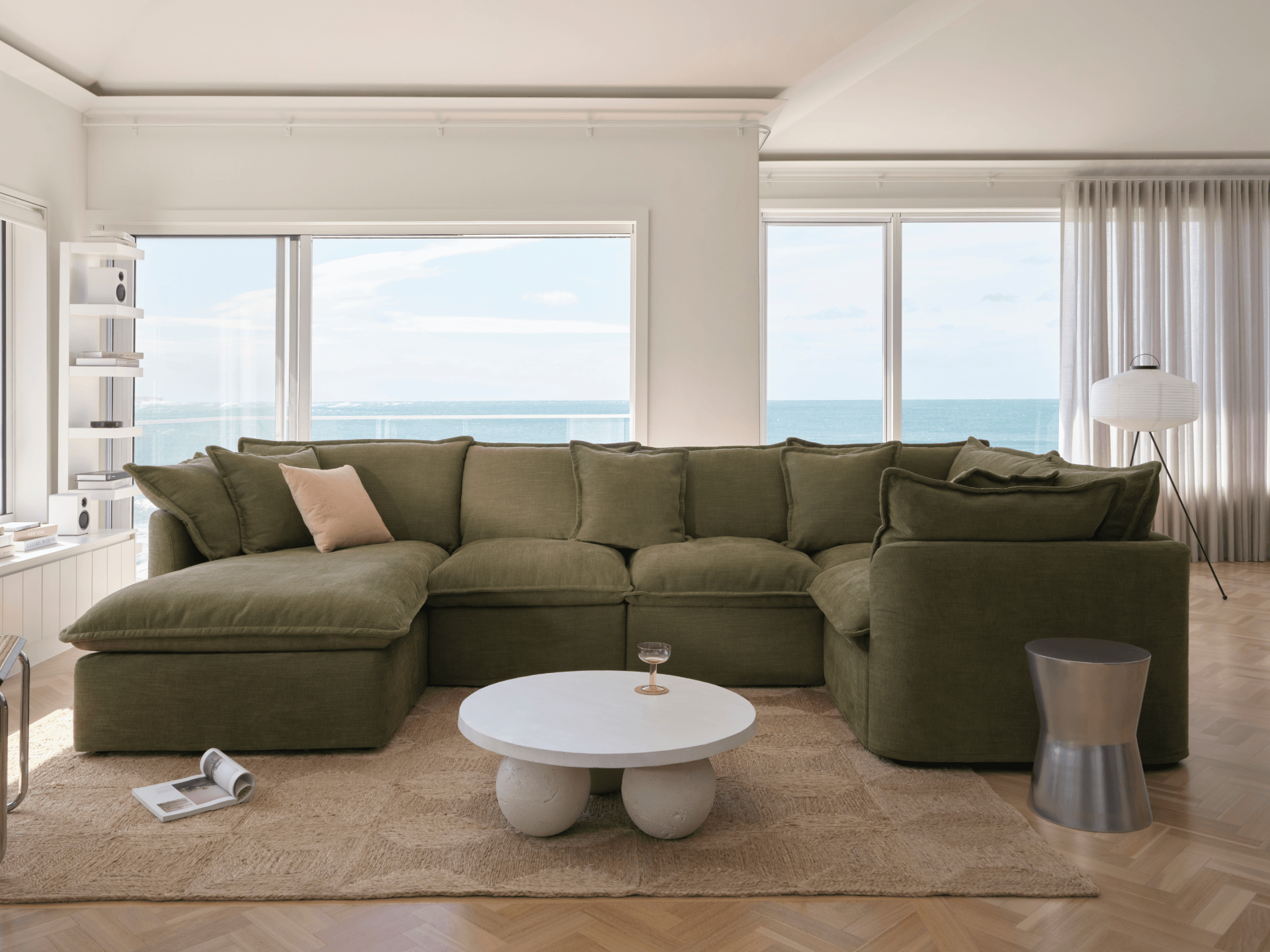 Olive green Koala Tamworth modular sofa in U-shape configuration in coastal living room with ocean views