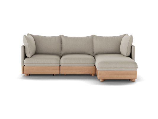 Light grey modular sectional sofa with wooden base, featuring three seat cushions and a chaise lounge on the right side.