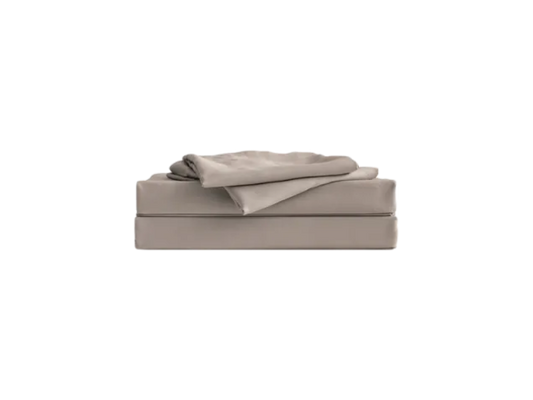 Folded beige sheet set on a bed in a box mattress, minimal design.