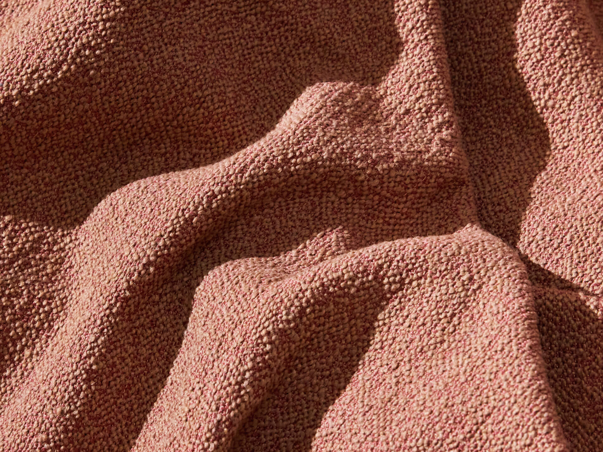 Textured beige fabric with a wavy pattern, highlighted by soft lighting, showcasing material detail and natural folds. Ideal for upholstery use.