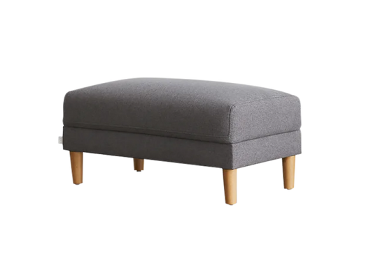 Grey fabric ottoman with light brown wooden legs, featuring a simple rectangular design. Ideal for modern living rooms or lounges.