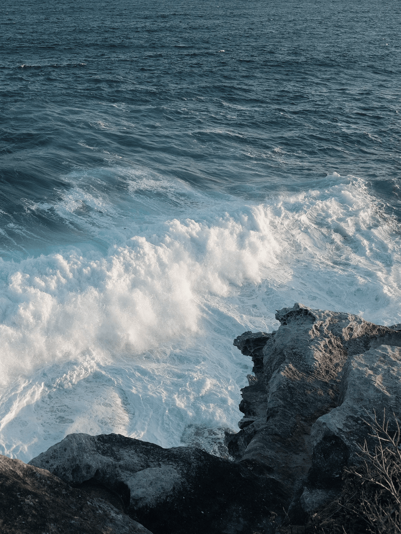 Waves crashing against rocky Australian coastline viewed from above