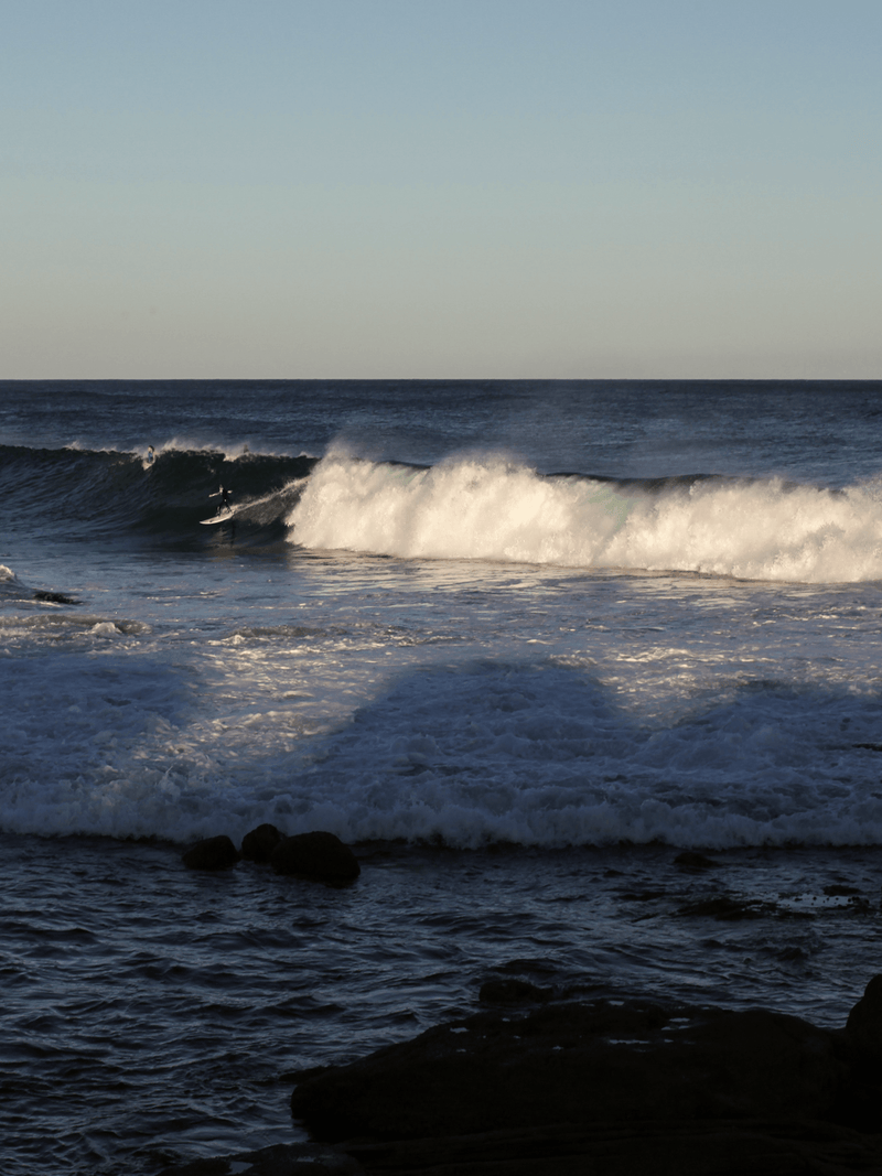 Australian ocean waves breaking over rocky coastline at golden hour