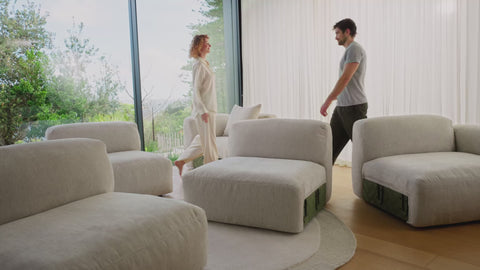 a lgiht gray sofa being put together easily by two people