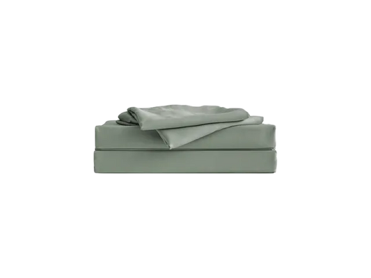 A sage green folded sheet set with a fitted and flat sheet stacked neatly on top of each other.